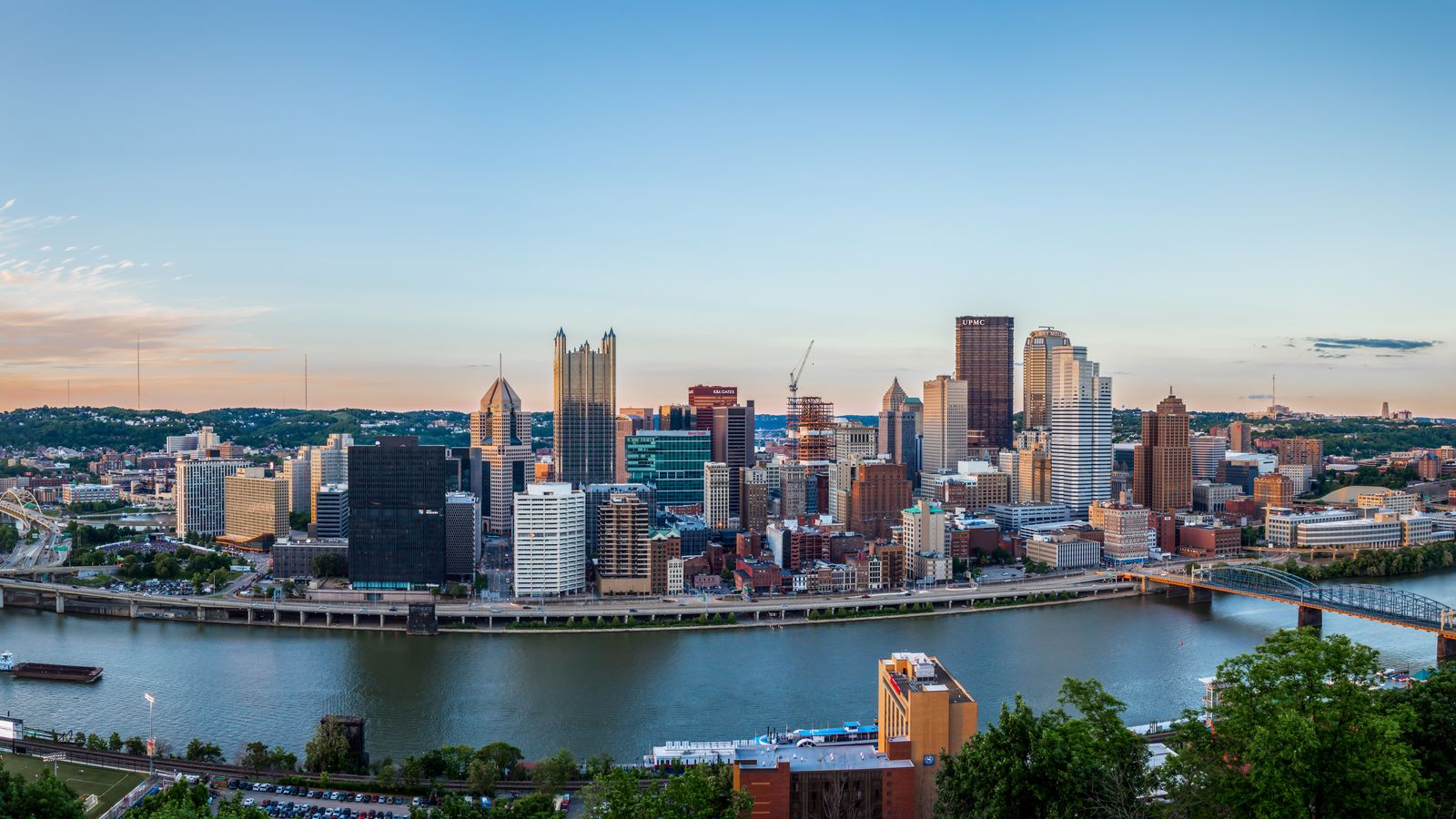 Downtown Pittsburgh at dusk, seen from Mount Washington across the river, with the skyline and the bridges beside it.