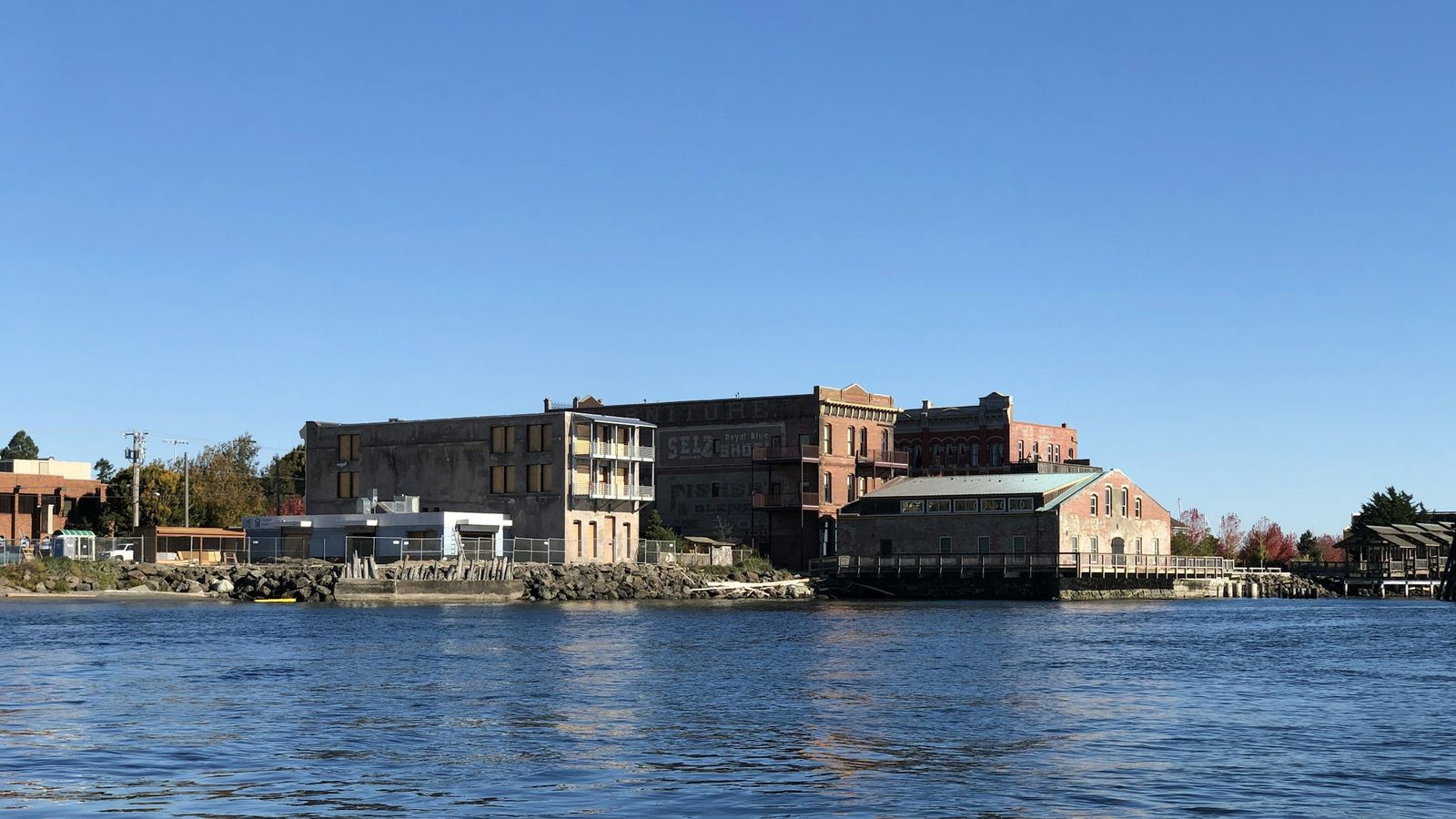 Port Townsend's Victorian brick buildings along the waterfront, seen from the water on a clear day.