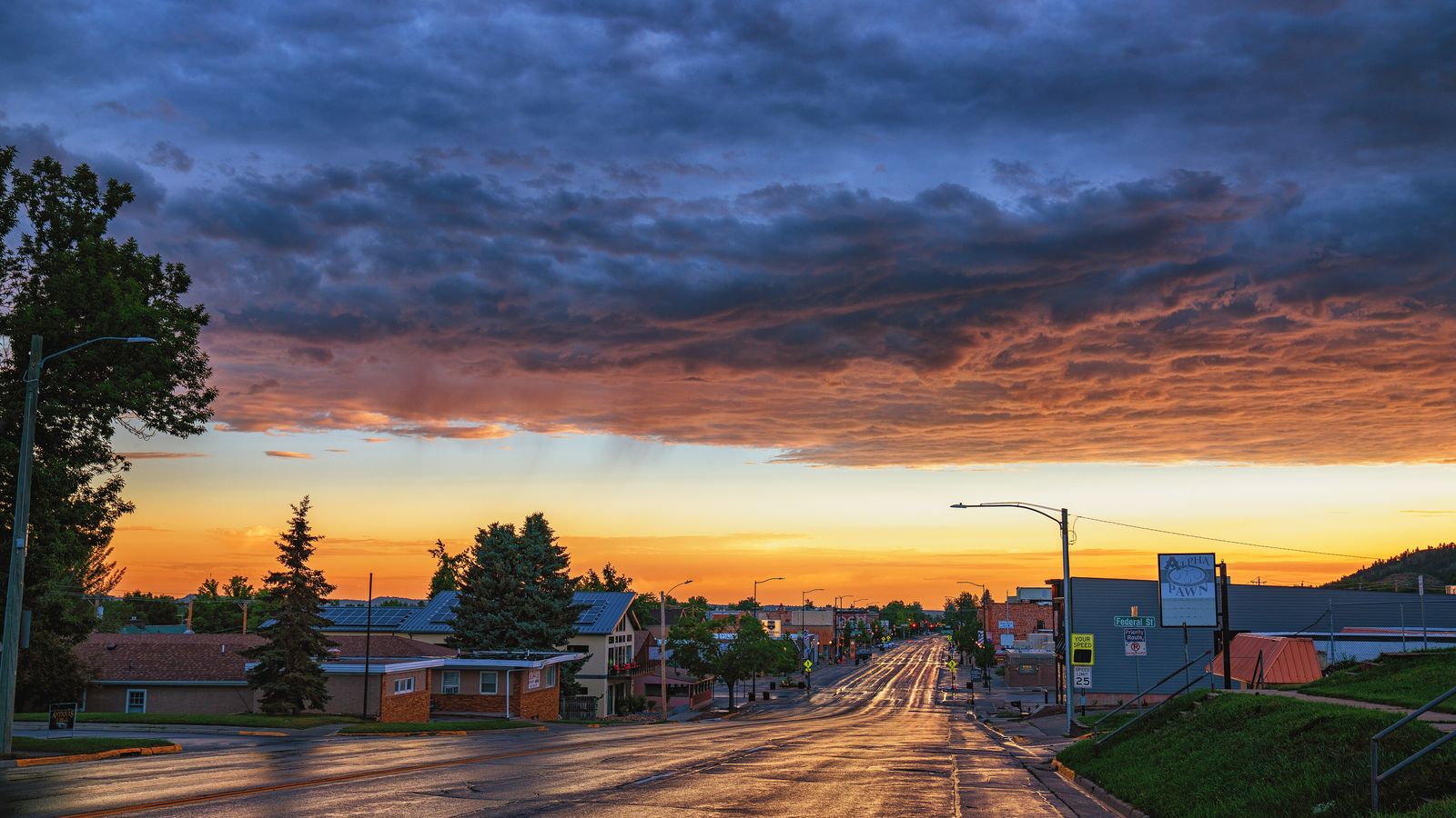 Main Street in Spearfish at sunrise under an orange and blue sky.