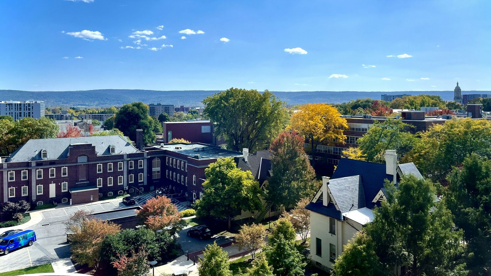 State College from above in autumn: brick buildings, trees turning color and a long ridge on the horizon.